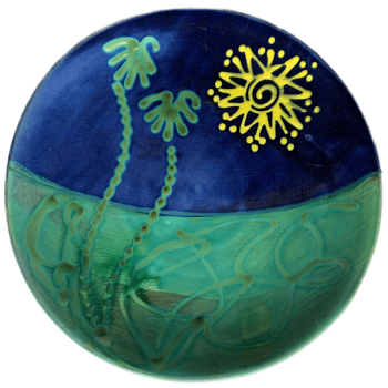 Round pottery design with sun and palm tree pattern.