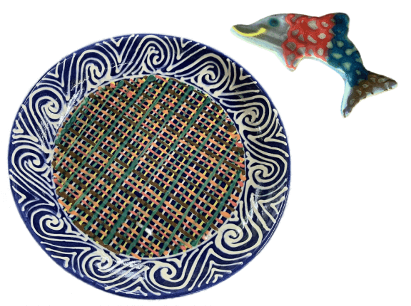 Custom pottery plate with colorful woven pattern, and a whimsical dolphin ceramic ornament